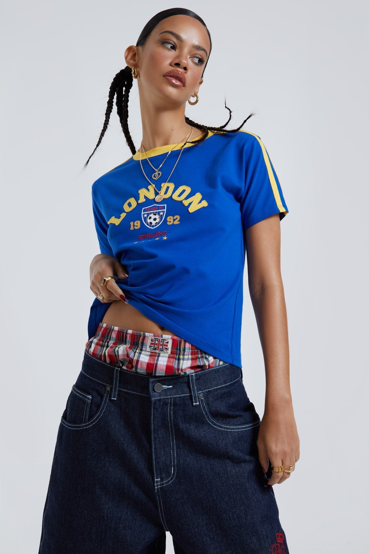 Female wearing blue baby style t-shirt with embroidered detail. Styled with oversized blue denim jorts. 